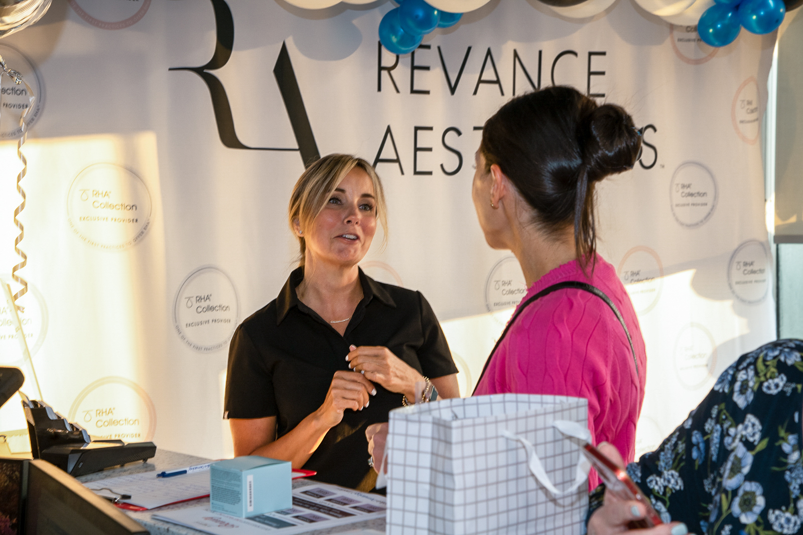 Dermatologist talking to woman in-front of sign