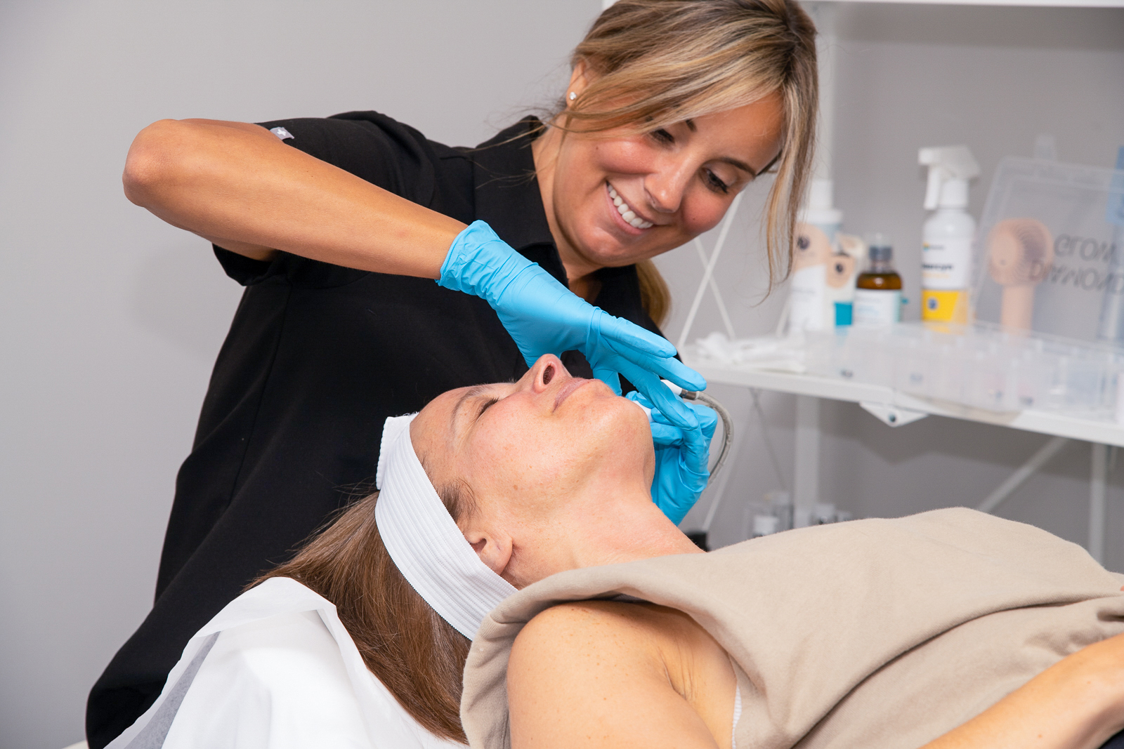 Aesthetician providing a DiamondGlow treatment to patient