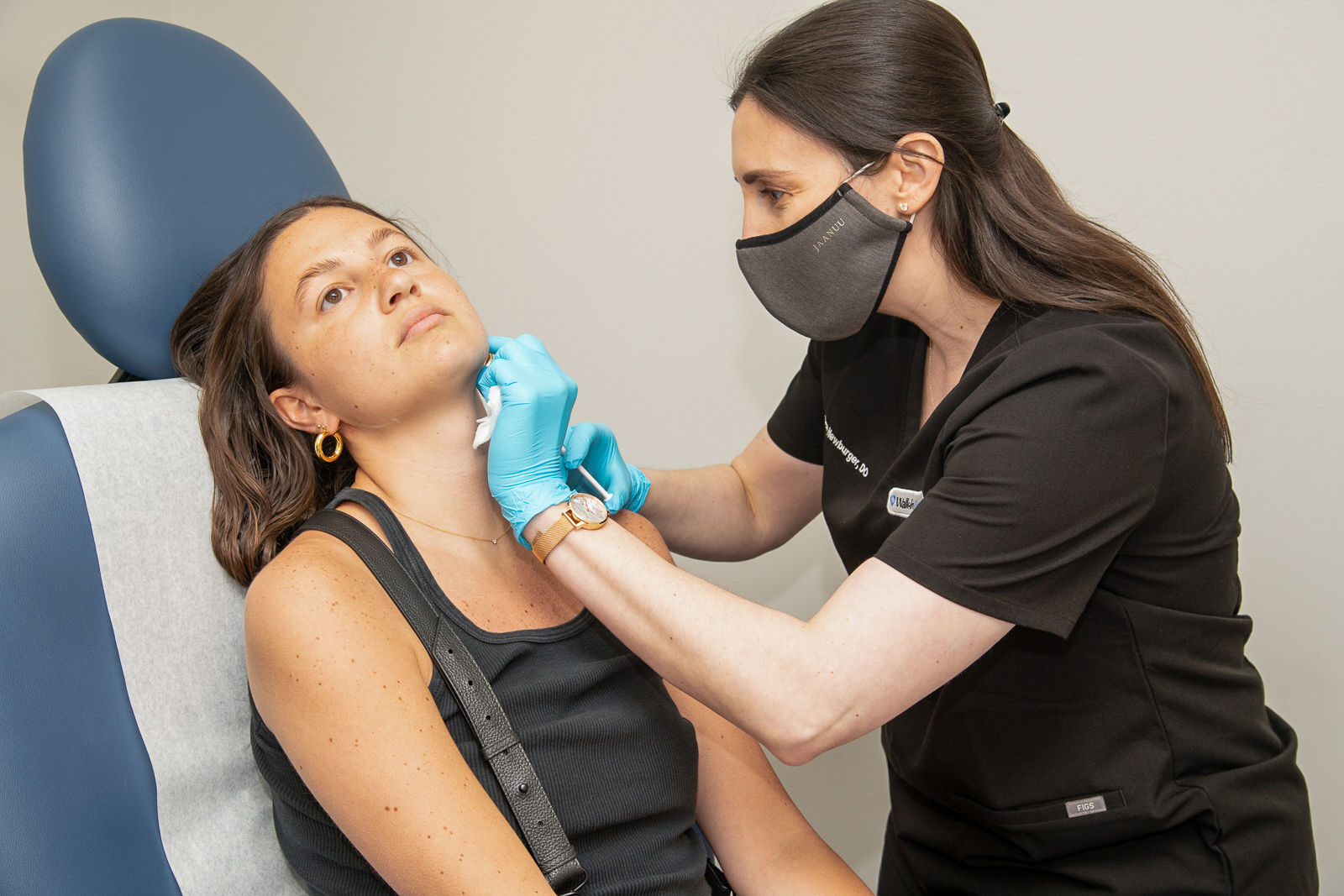 Woman getting treatment by Dermatologist while sitting down at A Night of Beauty Event